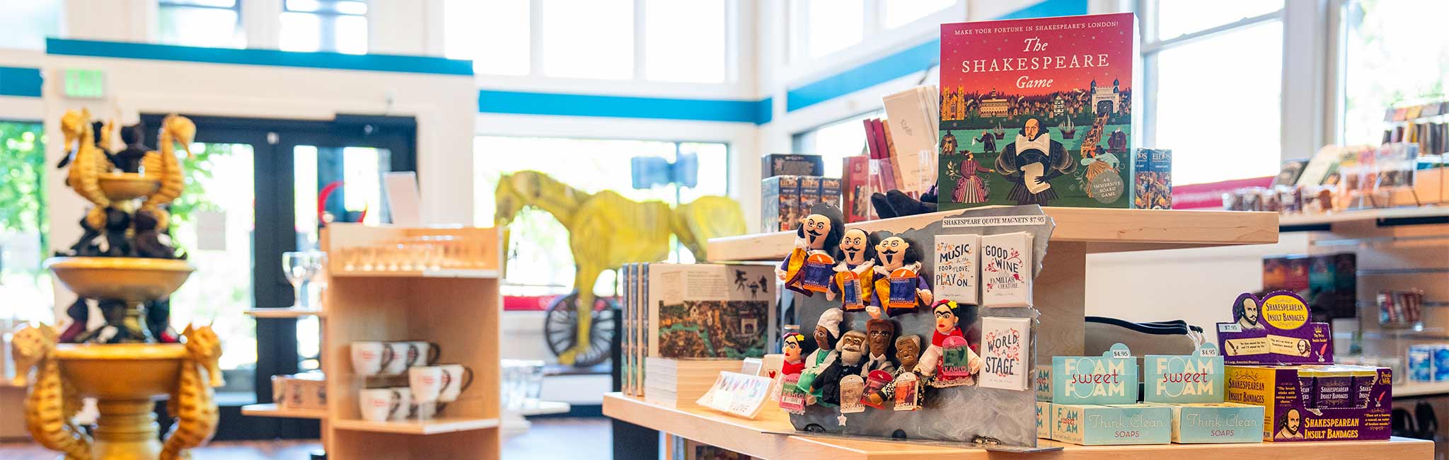 Inside of the new gift shop, showing books, toys and a large prop horse in the background.