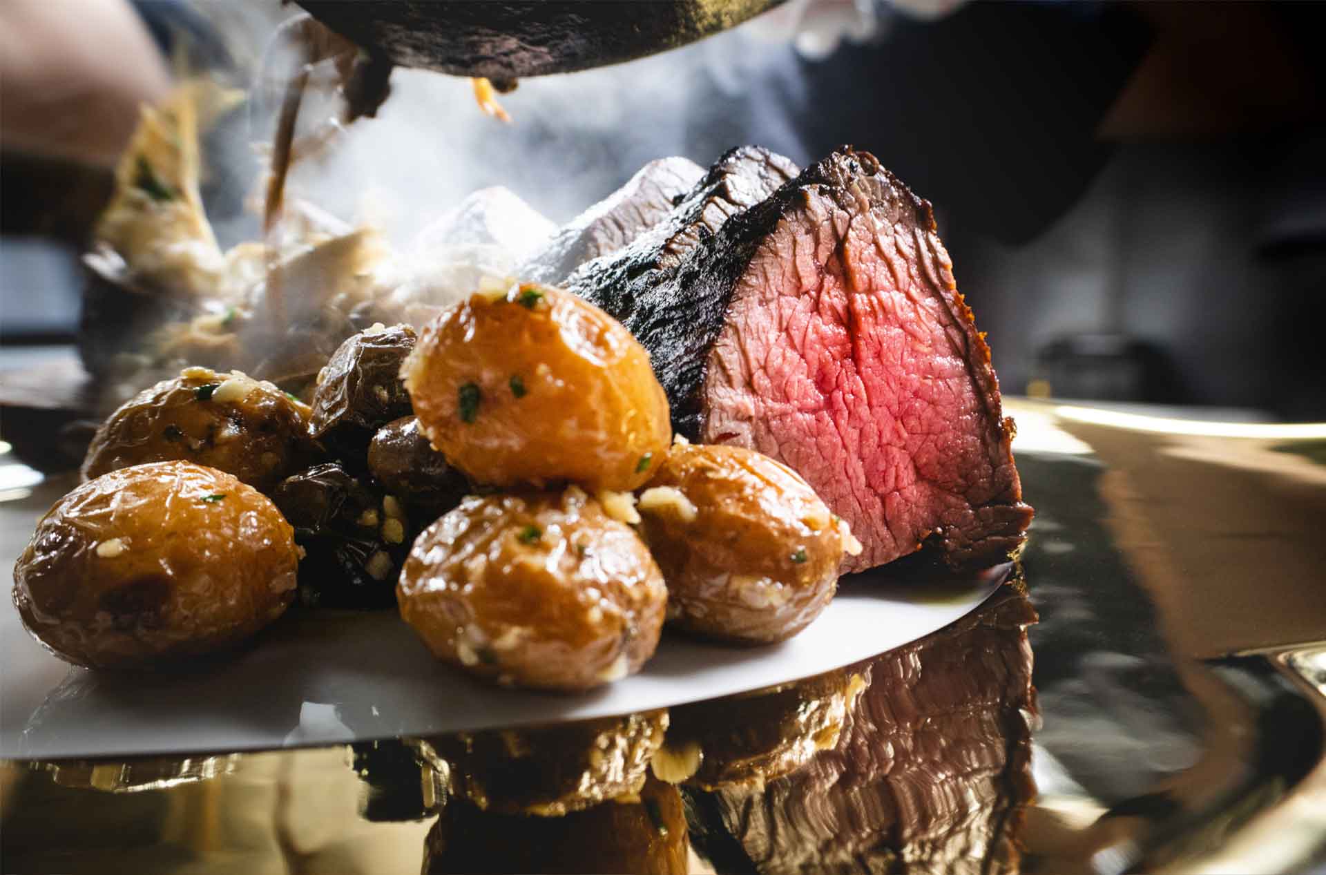 A steak with potatoes as a side.