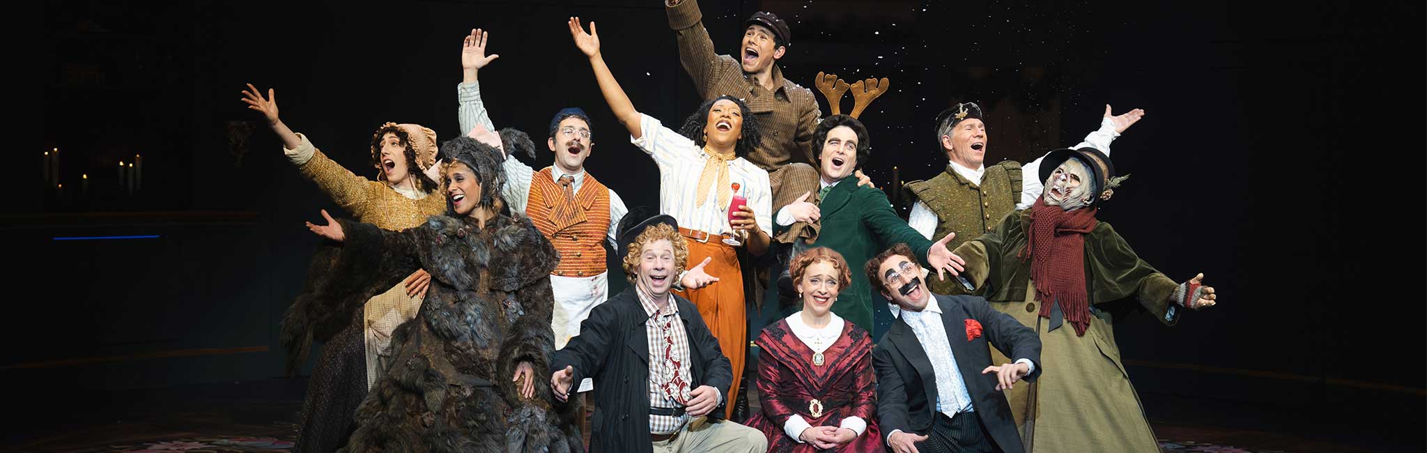 The cast of It's Christmas, Carol! singing and smiling out at the audience.