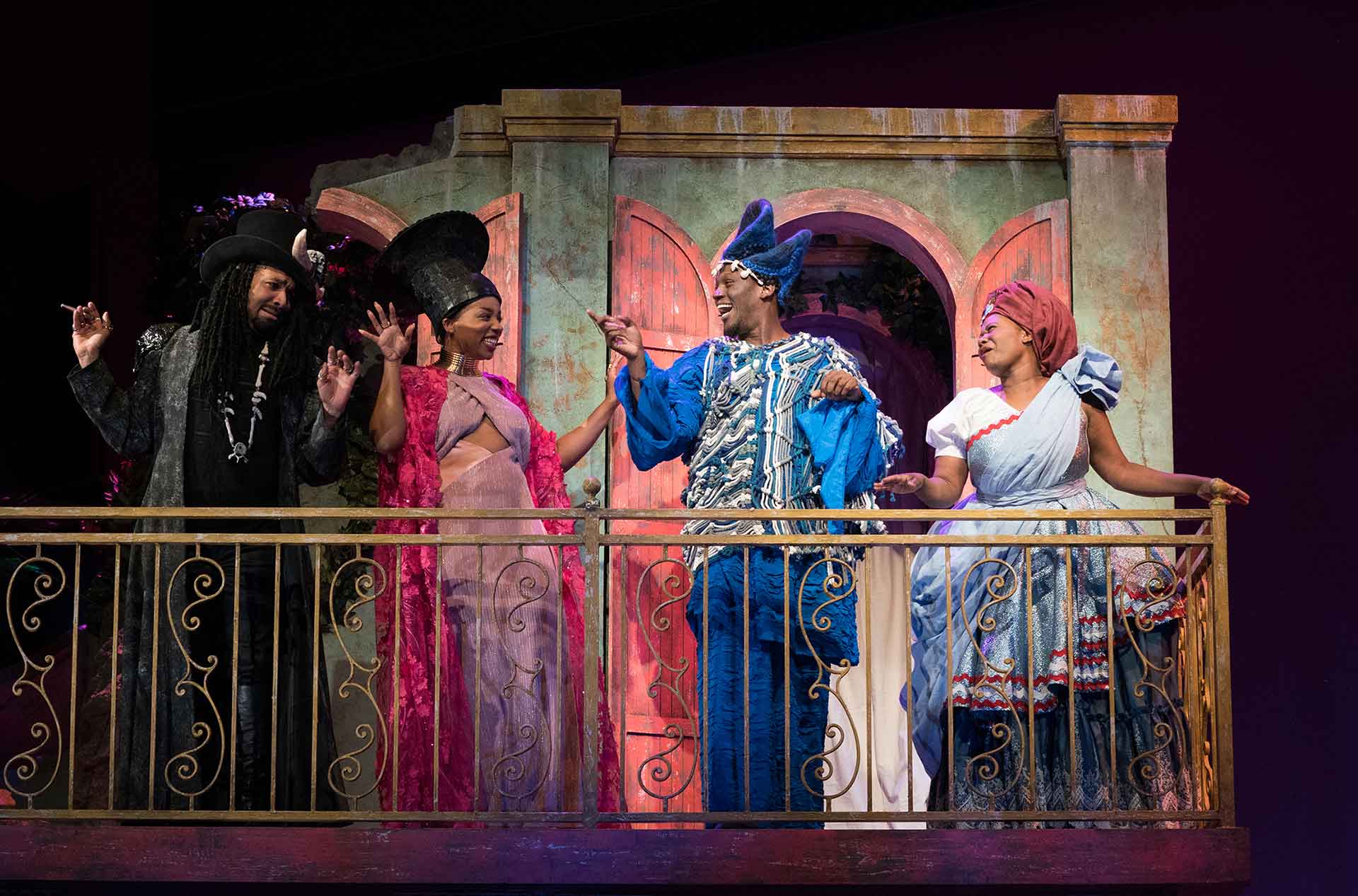 Four people standing on a balcony.