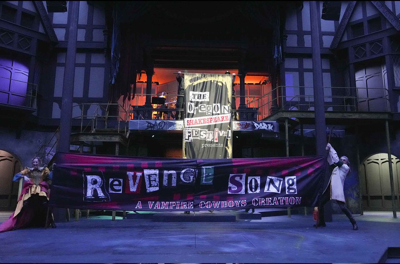 Two people holding a large banner that reads Revenge Song.