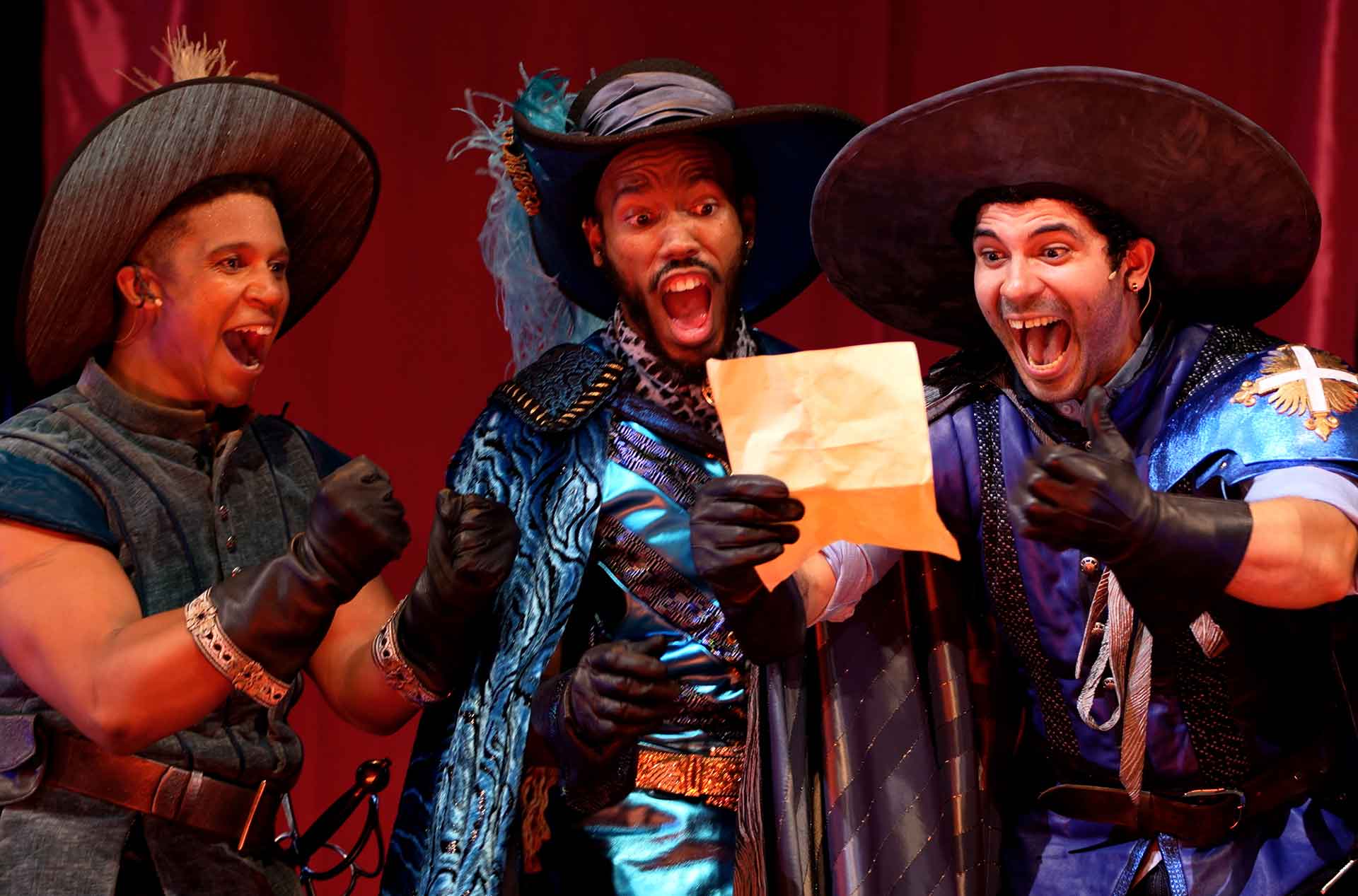 The Three Musketeers looking at a piece of paper with surprised expressions.