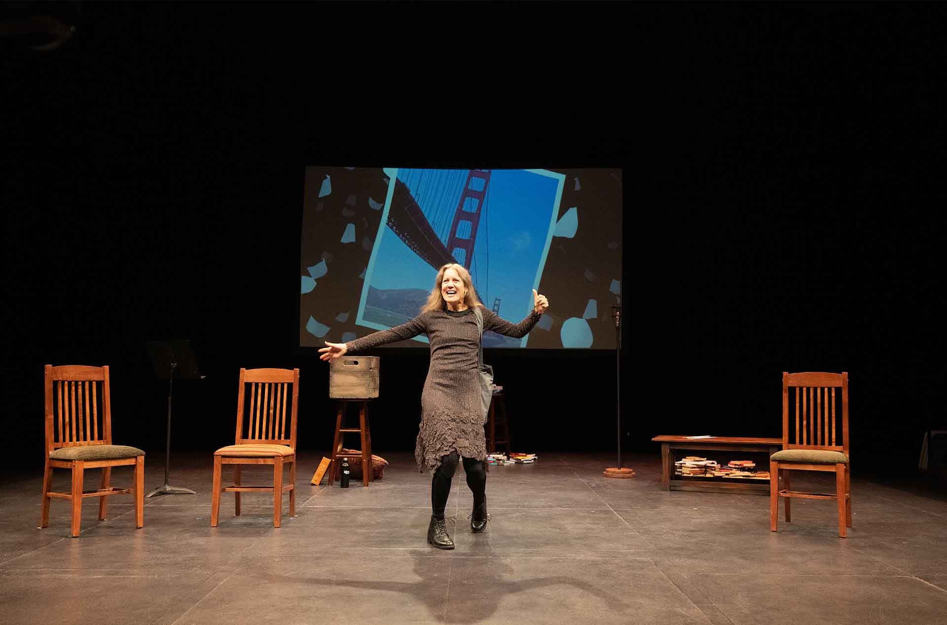 A woman with her arms out and her thumb in the air.