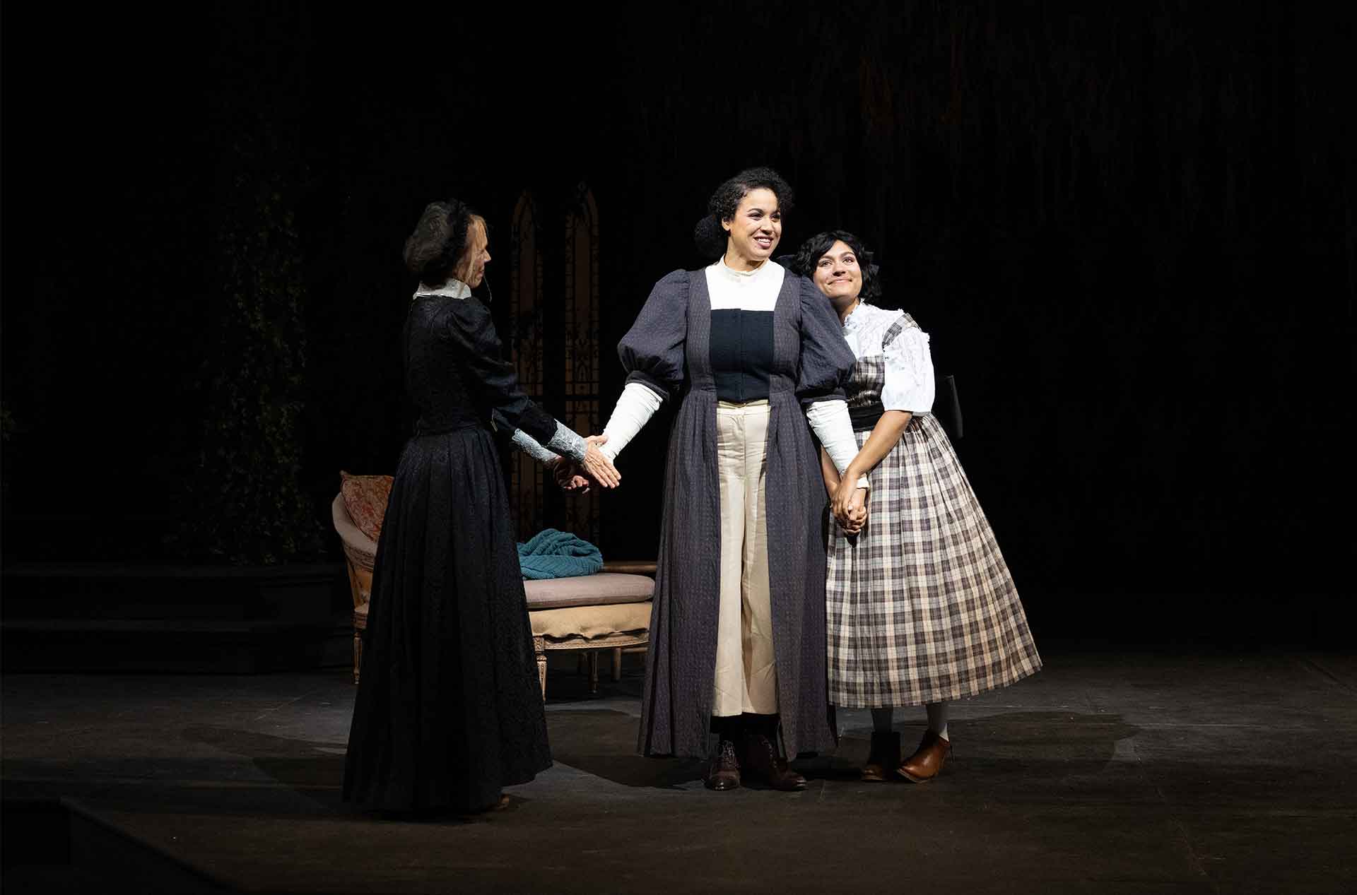 Three people holding hands standing together.