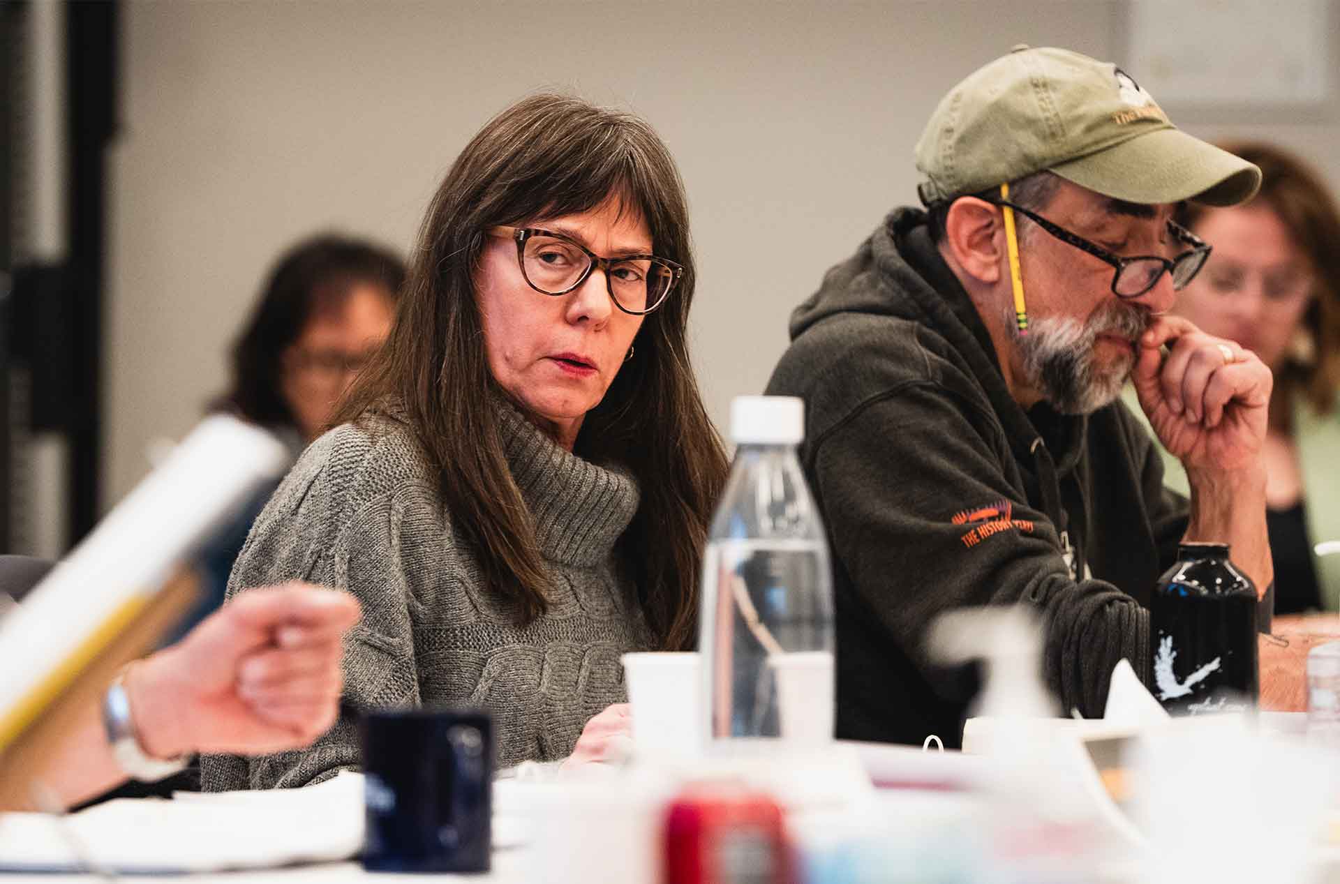 Two cast members listening during a table read rehearsal.