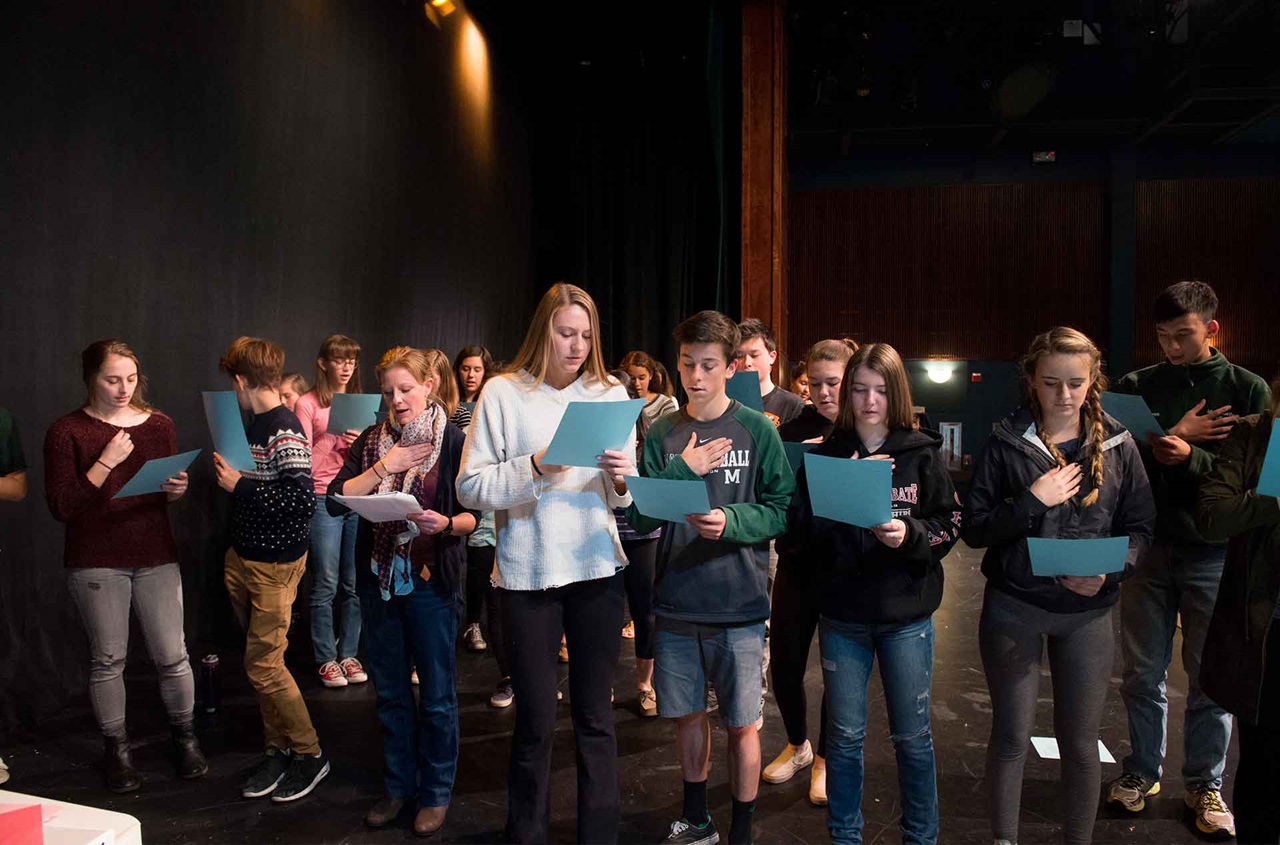A group of students reading from a script.