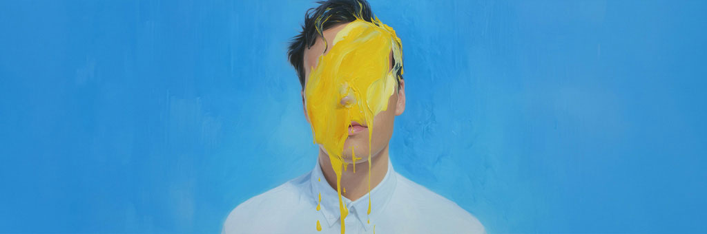 A person in a white shirt stands with their face obscured by a dramatic splash of yellow paint against a smooth blue background.